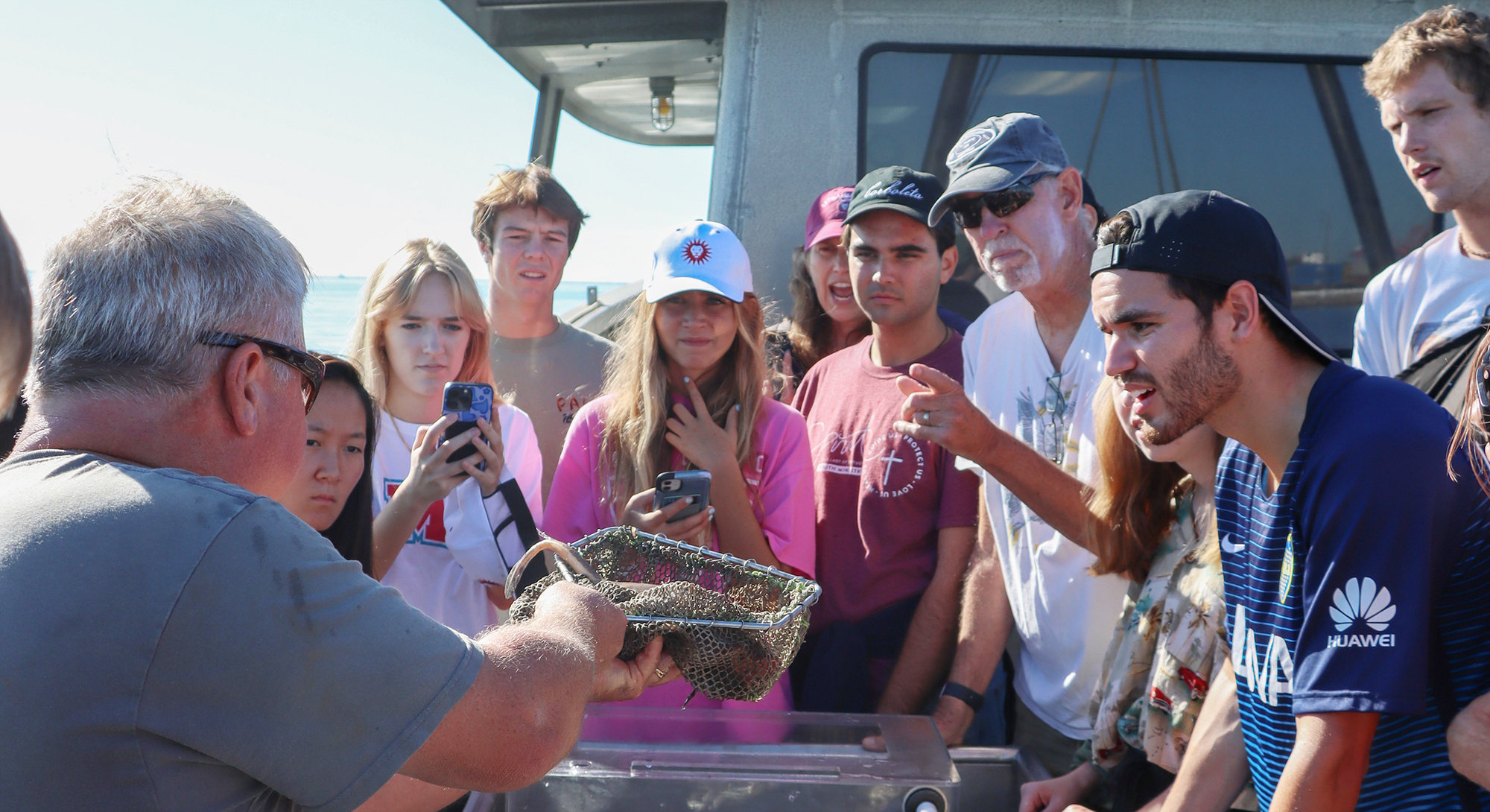 group of students participating in research out on a boat